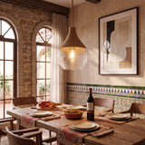 Lámpara de diseño colgante con pantalla de vidrio texturizado sobre mesa de comedor rústica.