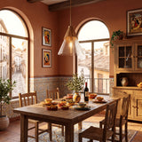 Lámpara colgante de mimbre sobre mesa de comedor de madera en salón rústico mediterráneo.