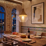 Lámpara de diseño colgante sobre una mesa de comedor rústica con decoración mediterránea.